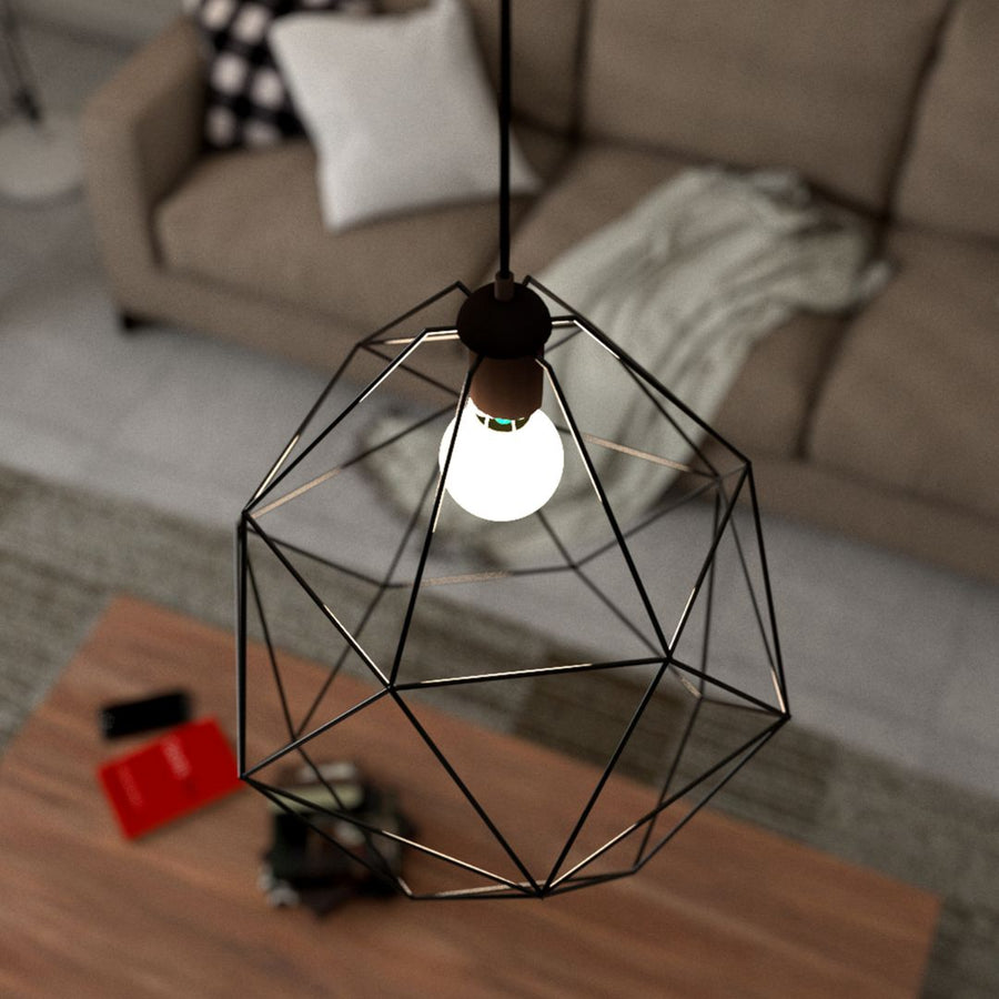 Black geometric pendant light with exposed bulb above wooden table